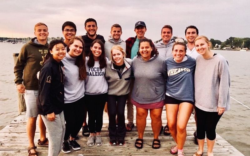 Group of young 20-somethings standing on a pier in a lake