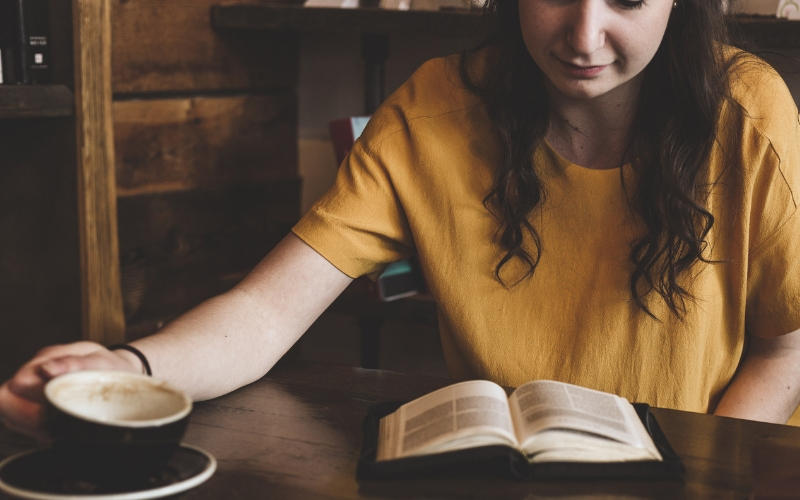 woman drinking coffee and studying her Bible