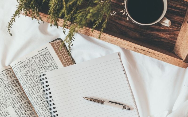 Bible, notebook, tray and coffee, houseplant