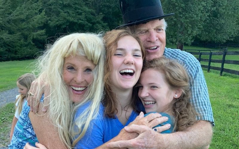 John and Susan Yates (in a top hat and wig) with two granddaughters.