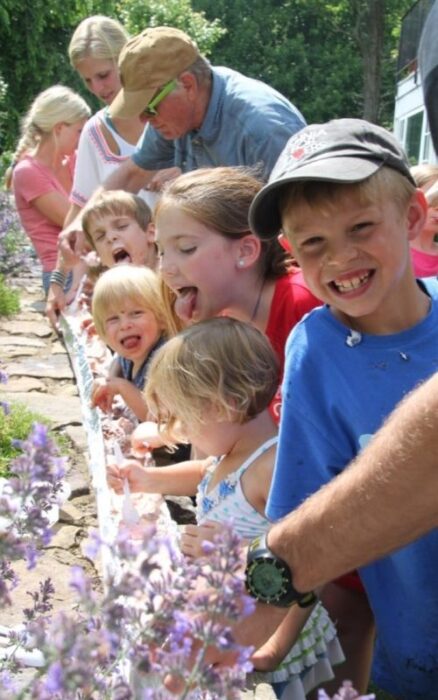 kids and grandparents eating a big ice cream sundae out of a gutter