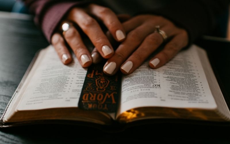 open Bible with a woman's hands on top