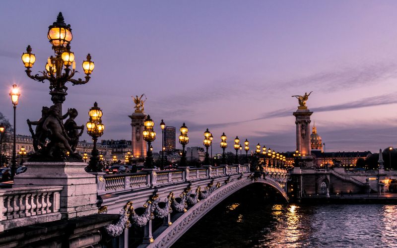 Paris bridge at night with streetlights.