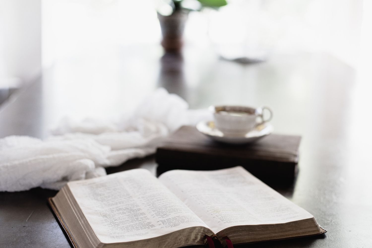 Bible, scarf and cup of coffee on dining room table